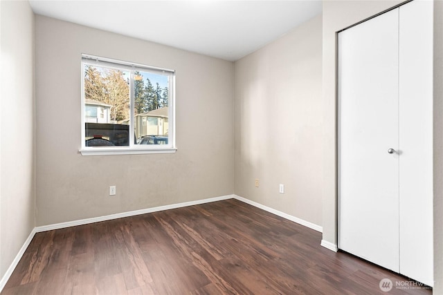 unfurnished bedroom with dark hardwood / wood-style floors and a closet