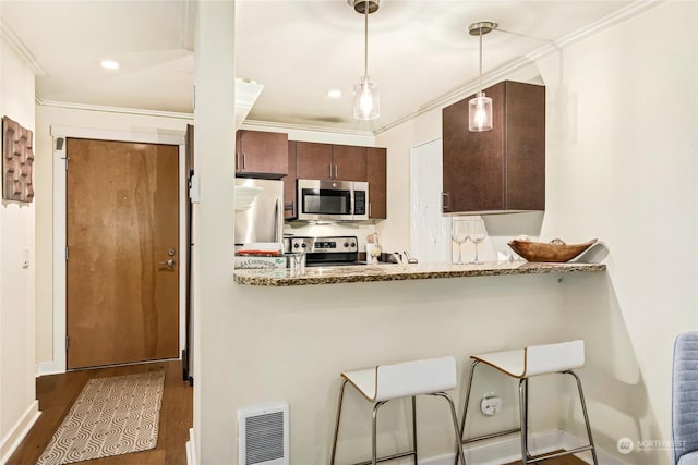 kitchen featuring stainless steel appliances, crown molding, light stone countertops, and hanging light fixtures