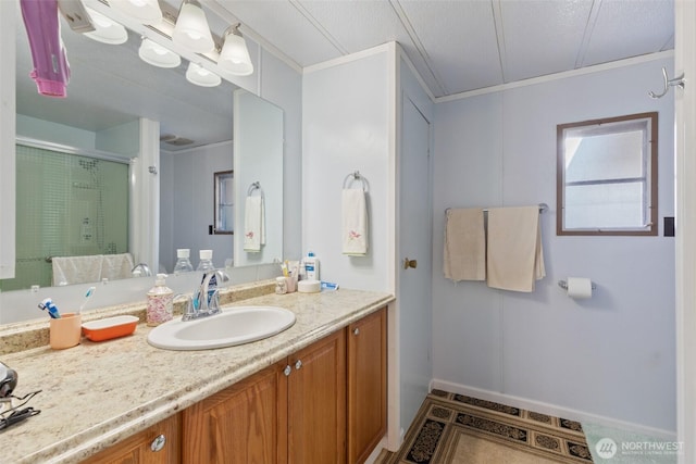 bathroom with vanity, an enclosed shower, and crown molding