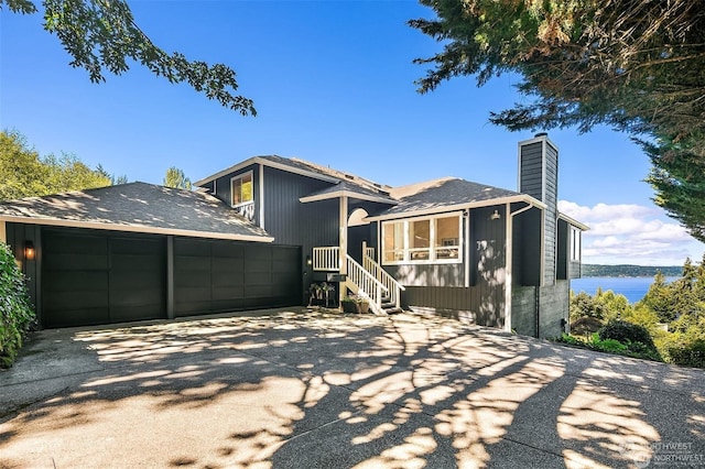 back of property featuring a garage and a water view