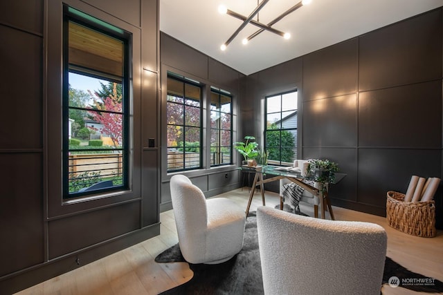 home office featuring a notable chandelier and light hardwood / wood-style flooring