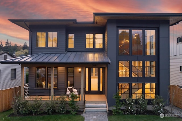 back house at dusk with covered porch