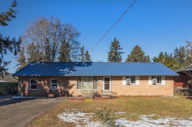 ranch-style home featuring a front yard and cooling unit