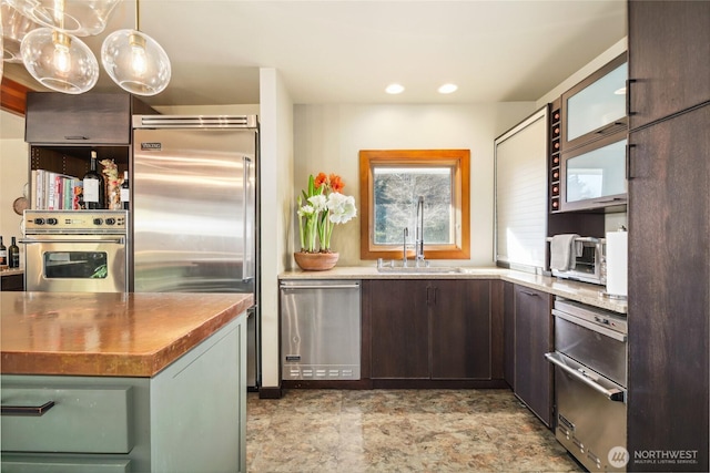 kitchen with a toaster, stainless steel appliances, butcher block counters, a sink, and dark brown cabinets