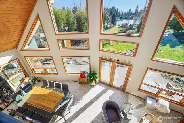 living room with high vaulted ceiling, a water view, carpet flooring, wood ceiling, and french doors