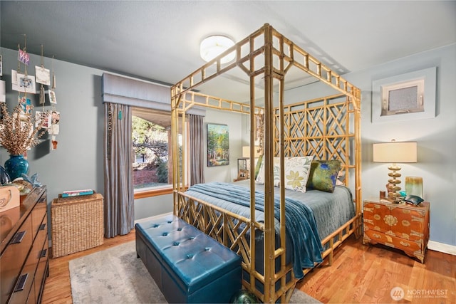 bedroom with wood finished floors and baseboards