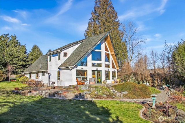 rear view of property with a patio area, a lawn, and roof with shingles