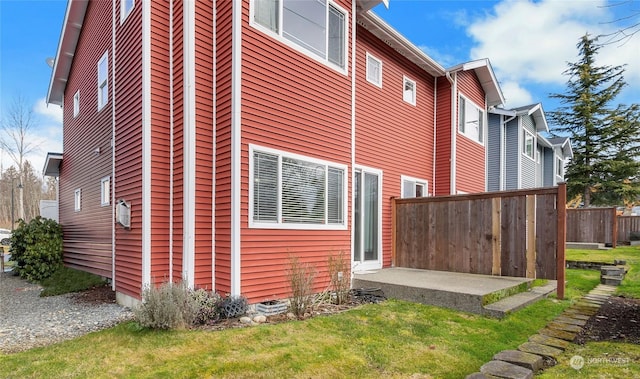 view of side of property featuring a yard and a patio area