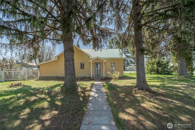 bungalow featuring metal roof, a front yard, and fence