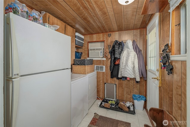 laundry room featuring laundry area, washer and clothes dryer, wooden walls, light tile patterned flooring, and wood ceiling