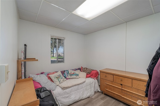 bedroom featuring wood finished floors and a drop ceiling