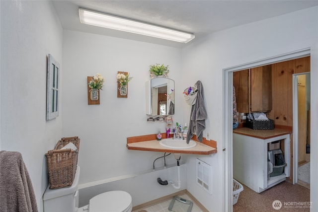 half bathroom featuring toilet, a sink, and visible vents