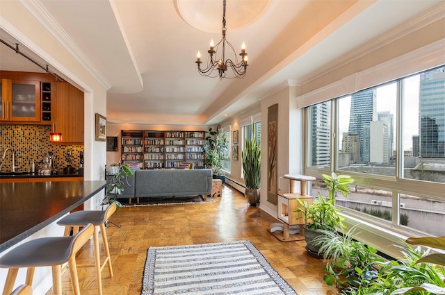 interior space featuring ornamental molding, light parquet flooring, a chandelier, and sink