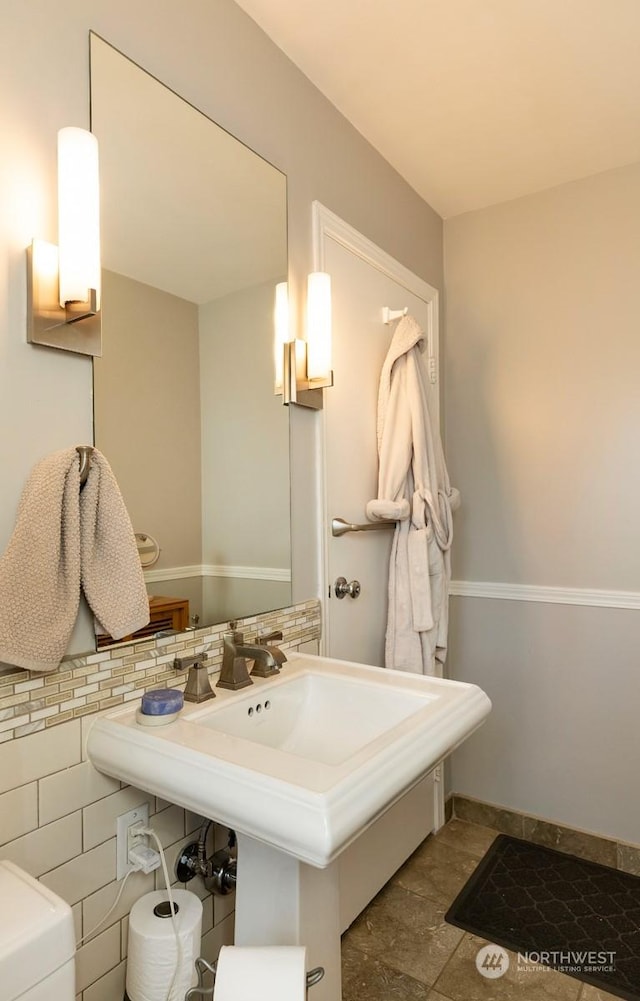 bathroom featuring sink and tile walls