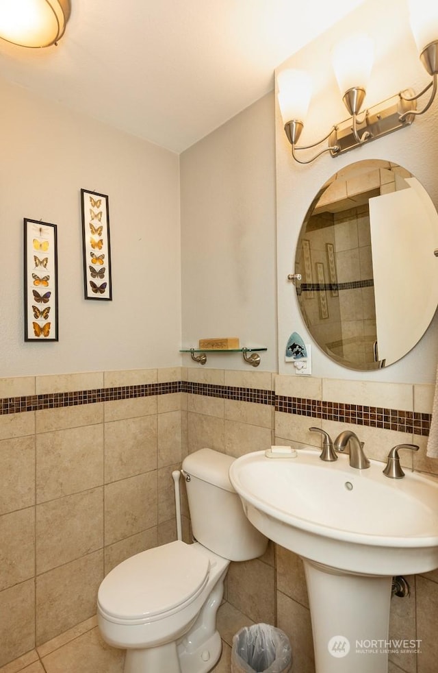 bathroom featuring sink, tile walls, tile patterned floors, toilet, and a chandelier