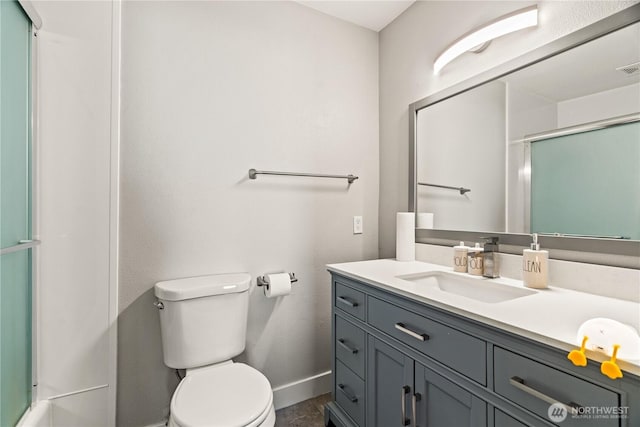 bathroom featuring vanity, toilet, and a shower with shower door