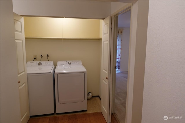 washroom with dark wood-type flooring and independent washer and dryer