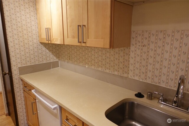 interior space with dishwasher, sink, and light brown cabinetry