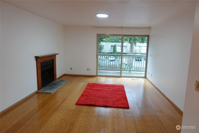 unfurnished living room featuring a fireplace and light hardwood / wood-style floors