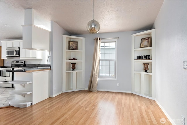 kitchen featuring sink, light hardwood / wood-style flooring, pendant lighting, stainless steel appliances, and white cabinets