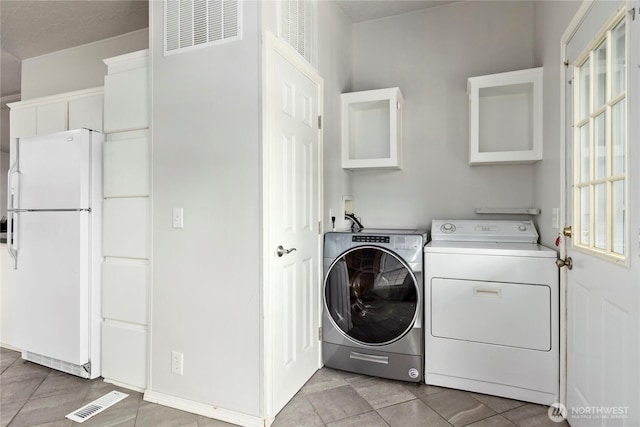 laundry room featuring washing machine and dryer and cabinets