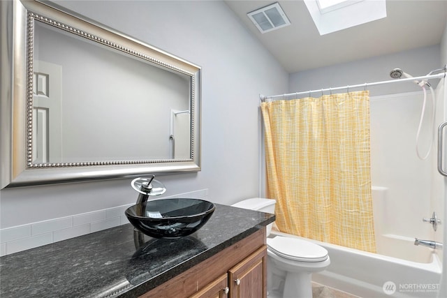 full bathroom with vanity, toilet, a skylight, and shower / tub combo