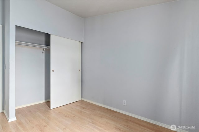 unfurnished bedroom featuring a closet and light wood-type flooring