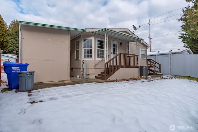 view of snow covered rear of property