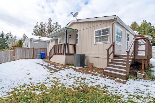 snow covered property featuring central AC unit