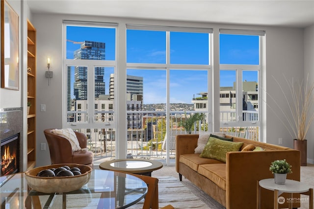 sunroom / solarium featuring a warm lit fireplace and a view of city