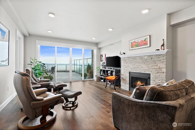 living room featuring dark wood-style floors, recessed lighting, a fireplace, and baseboards