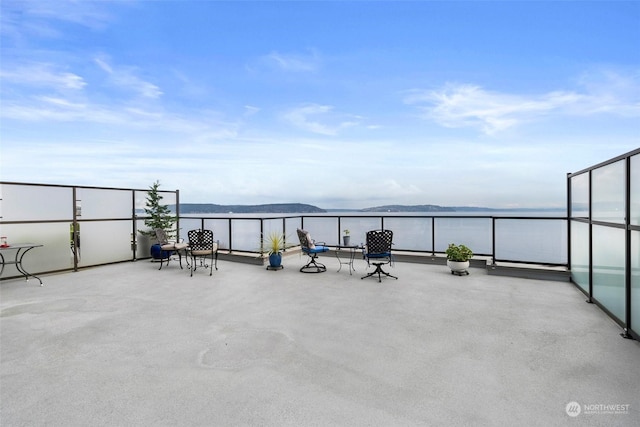 view of patio featuring a balcony and a water and mountain view