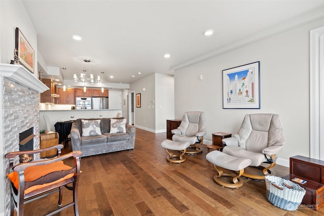 living area featuring baseboards, a chandelier, recessed lighting, a fireplace, and dark wood-style floors