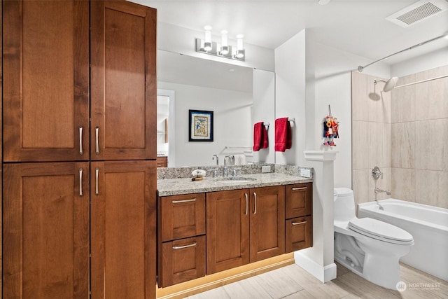 bathroom featuring bathtub / shower combination, toilet, visible vents, vanity, and a closet