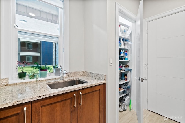 interior space with light stone counters, brown cabinets, and a sink