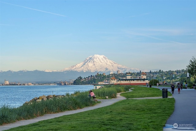 surrounding community with a lawn and a water and mountain view