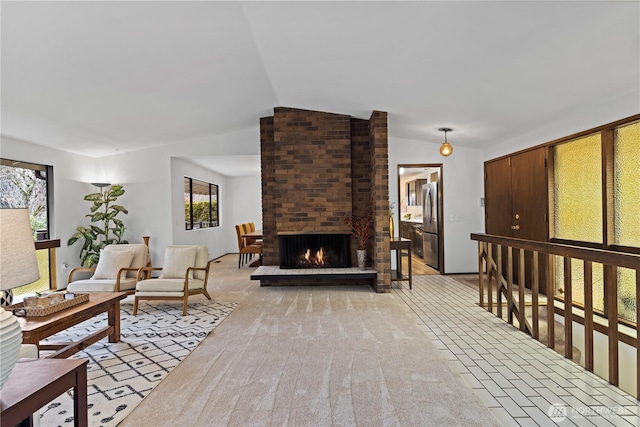 living room featuring light carpet, vaulted ceiling, and a fireplace