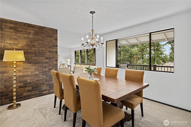 dining area with brick wall, a chandelier, and light colored carpet