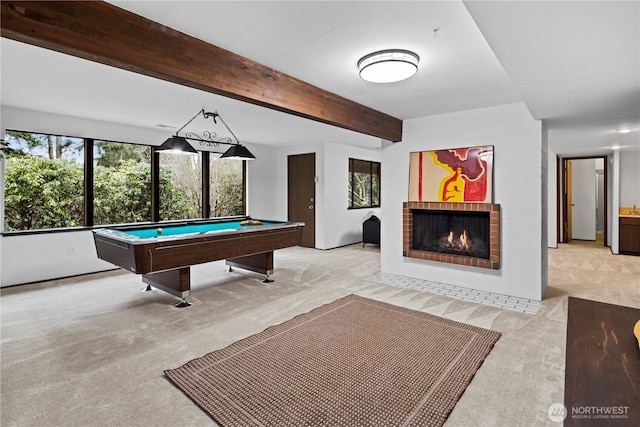 playroom featuring a brick fireplace, beamed ceiling, pool table, and light colored carpet