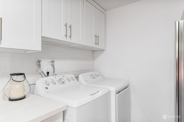 washroom featuring cabinets and separate washer and dryer