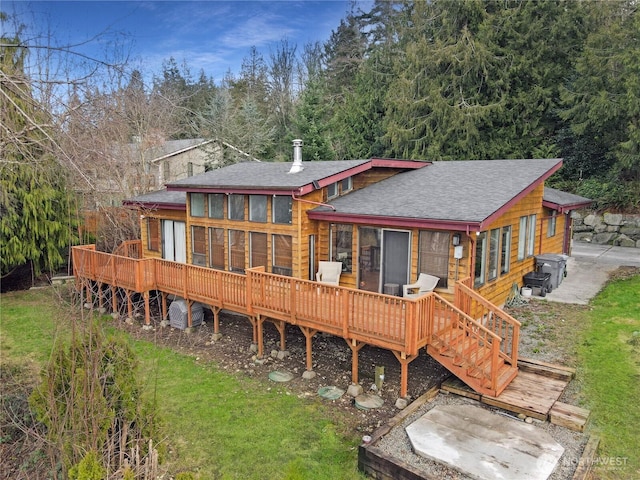 back of property with a deck and a shingled roof