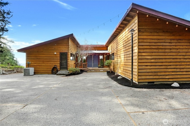 view of side of home with crawl space, cooling unit, and a patio area