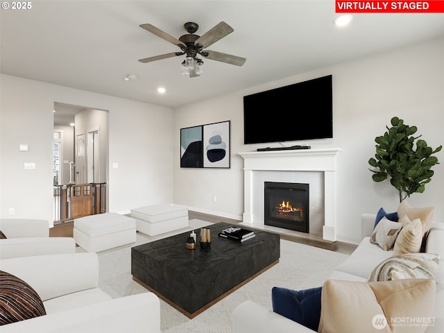 living area with a tile fireplace, baseboards, a ceiling fan, and recessed lighting