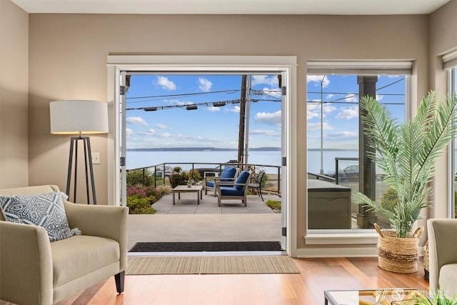 doorway to outside with hardwood / wood-style flooring and a water view