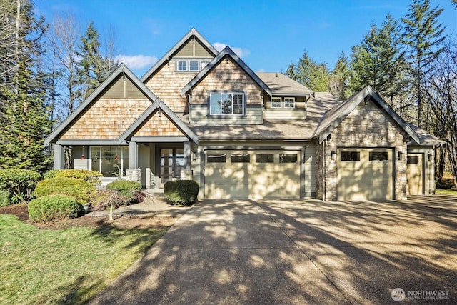 craftsman-style house featuring a garage, concrete driveway, and stone siding