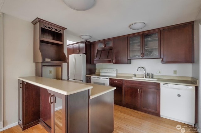 kitchen featuring sink, light hardwood / wood-style flooring, kitchen peninsula, custom range hood, and white appliances