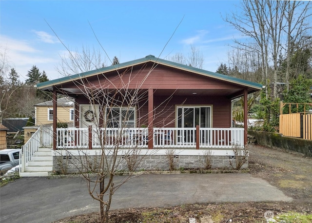 rear view of property featuring covered porch