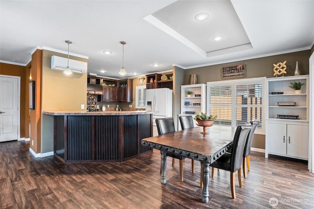 dining area with crown molding, dark hardwood / wood-style floors, a wall mounted AC, and a tray ceiling