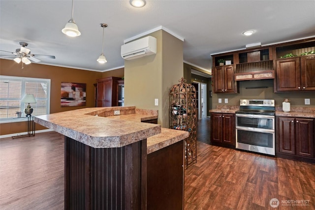 kitchen featuring dark wood-type flooring, a wall mounted AC, dark brown cabinets, hanging light fixtures, and range with two ovens