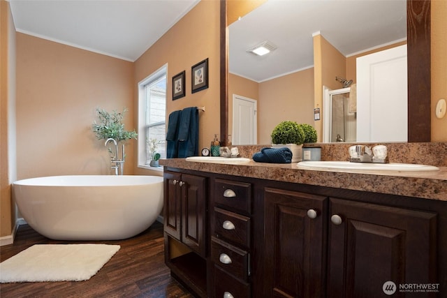 bathroom featuring vanity, separate shower and tub, ornamental molding, and hardwood / wood-style floors